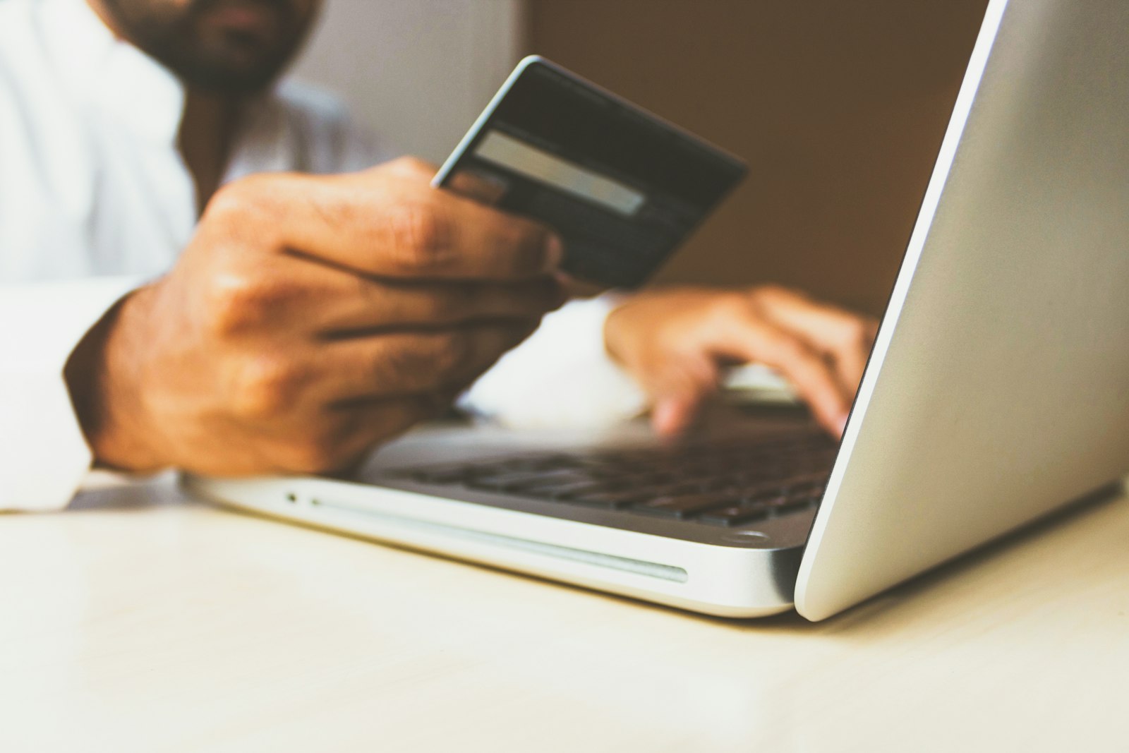 Person shopping online with a laptop and payment card